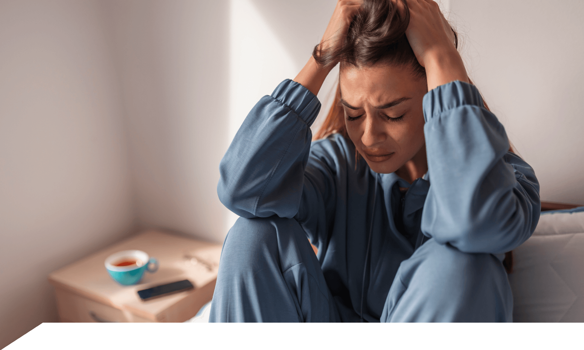 Woman sitting on bed frustrated