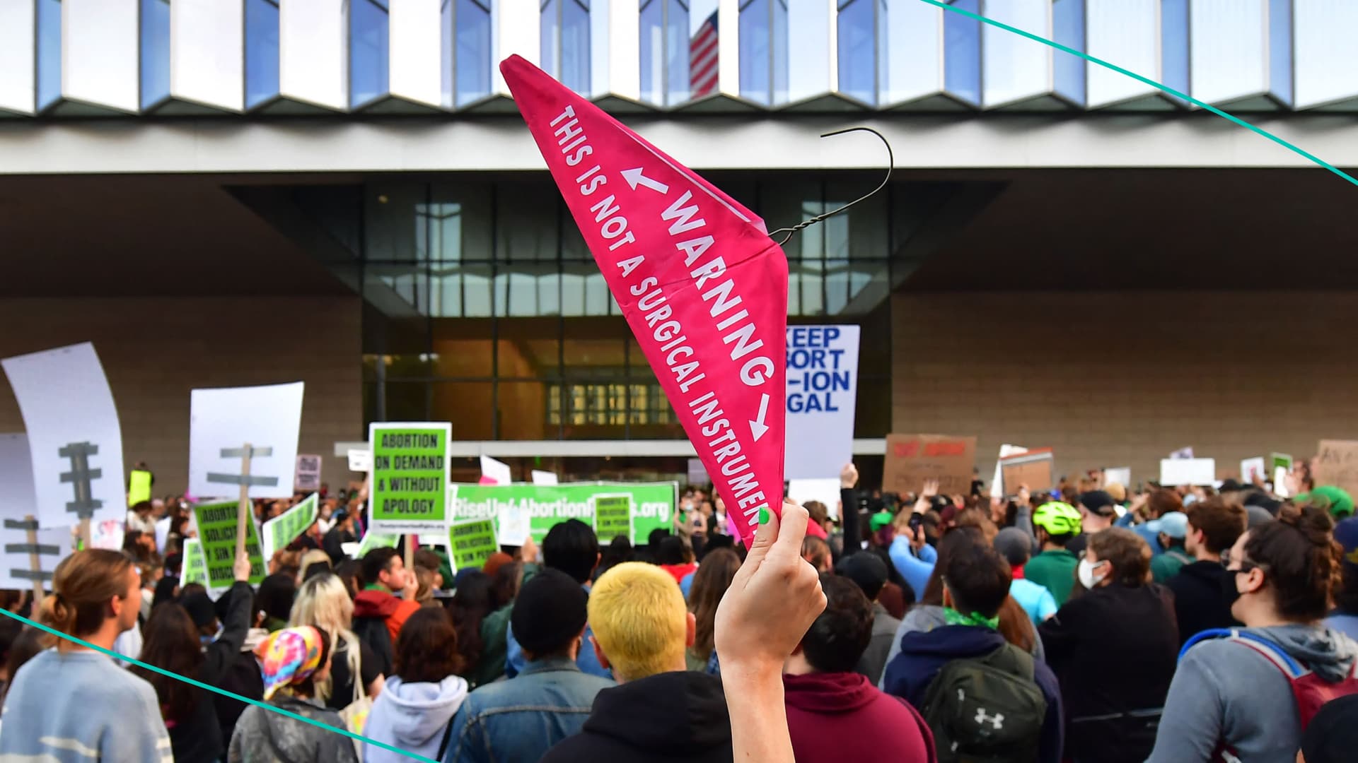 A person holds up a coat hanger, a symbol of the reproductive rights movement