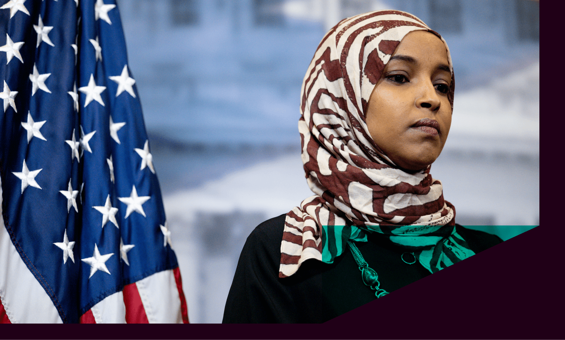 Representative Ilhan Omar (D-MN) stands next to an American flag