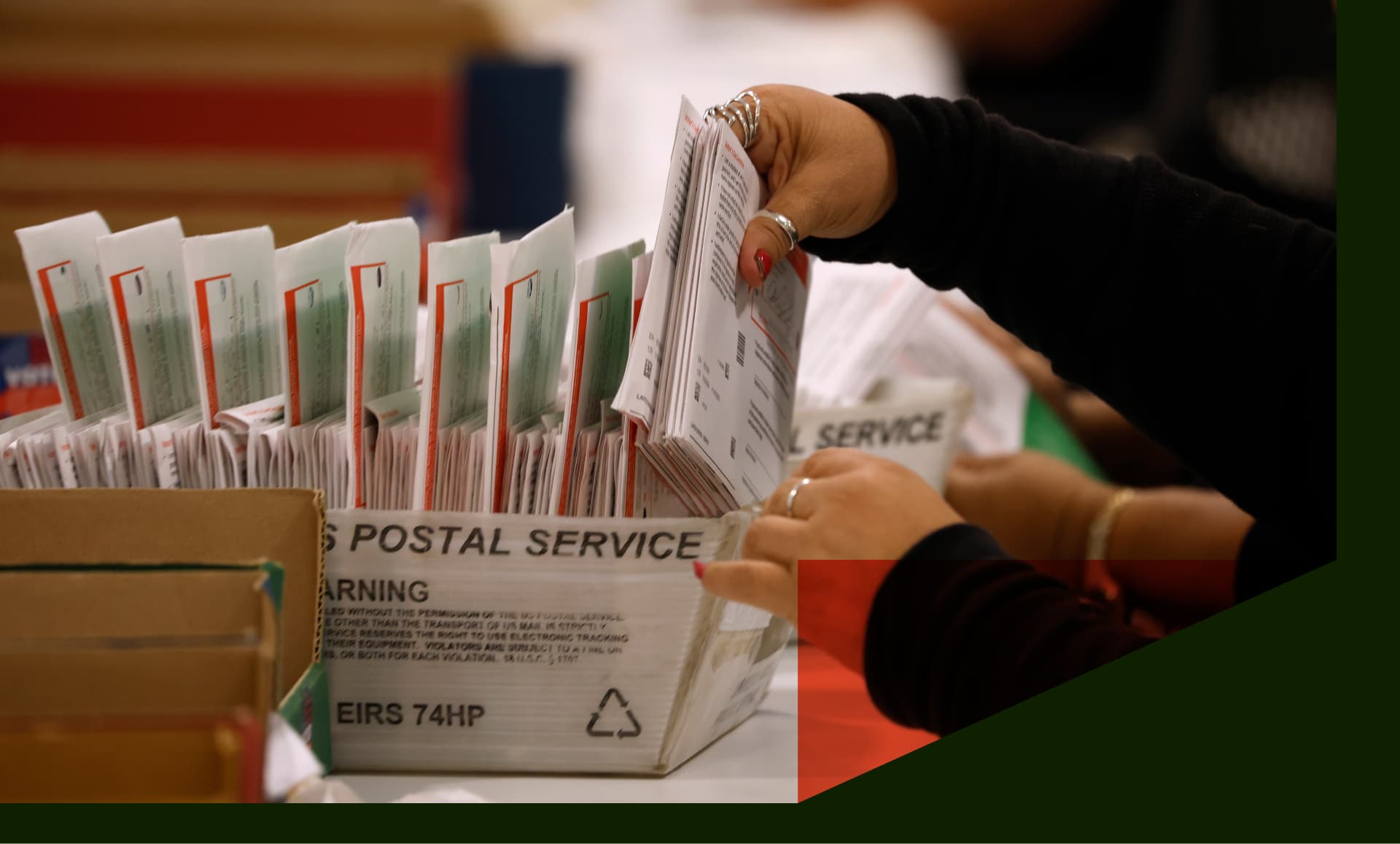 An election worker processes mail-in ballots