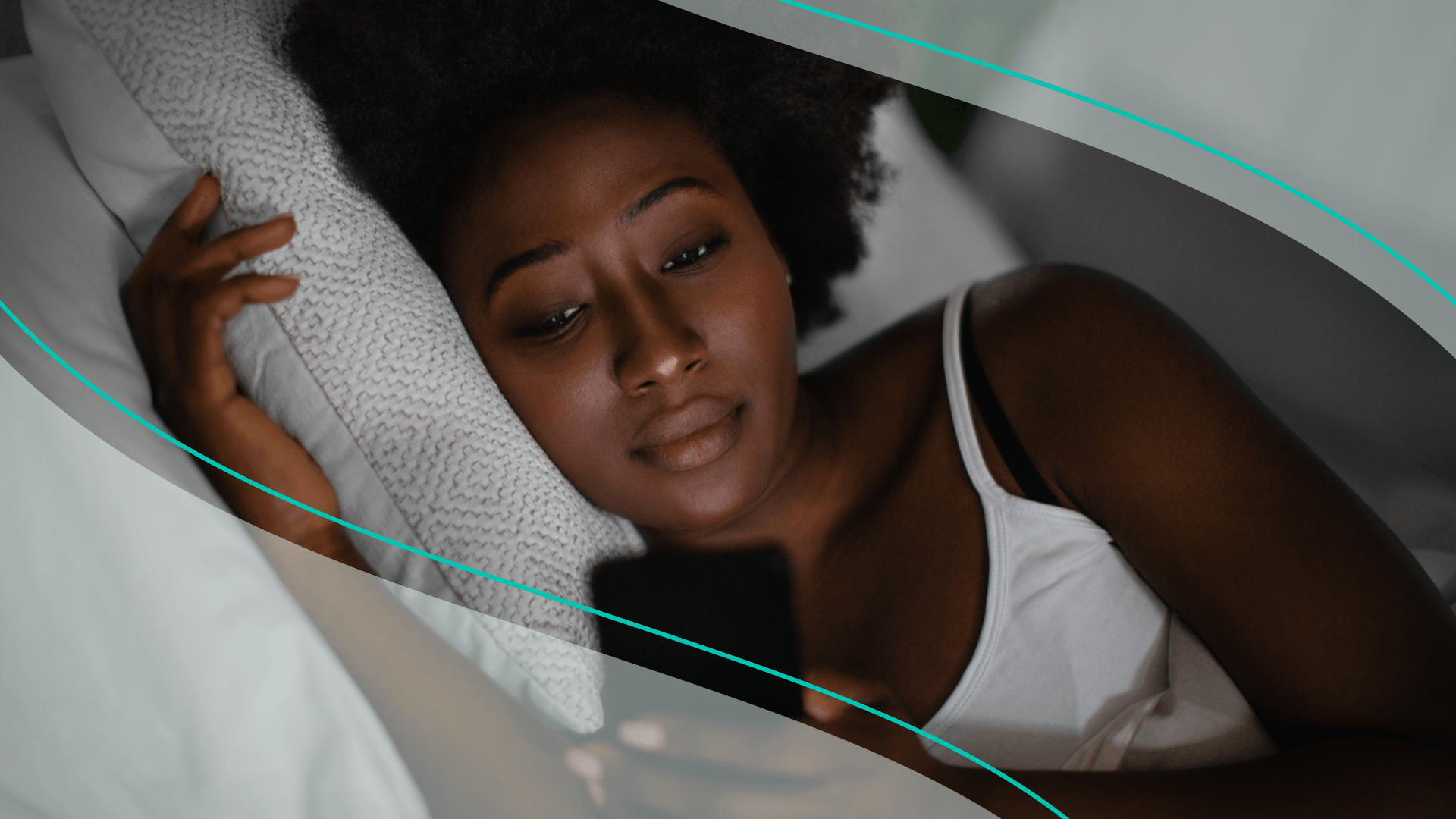 Woman lying in bed on her phone
