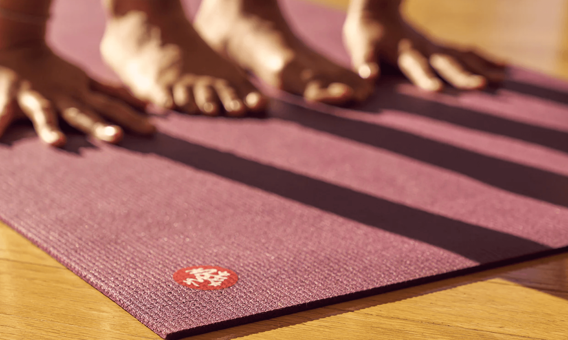 Person posing with hands and feet on purple yoga mat