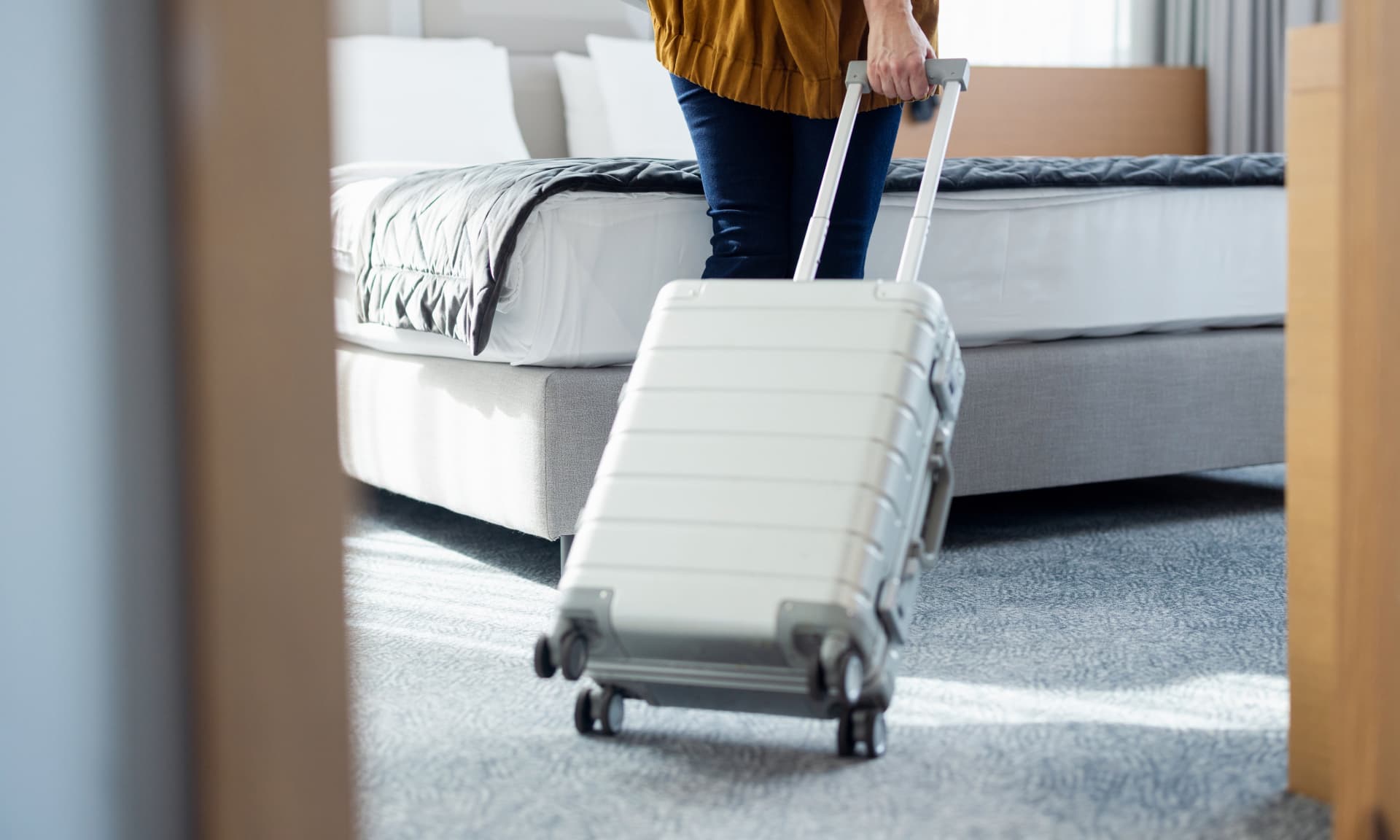 Woman with suitcase entering hotel room