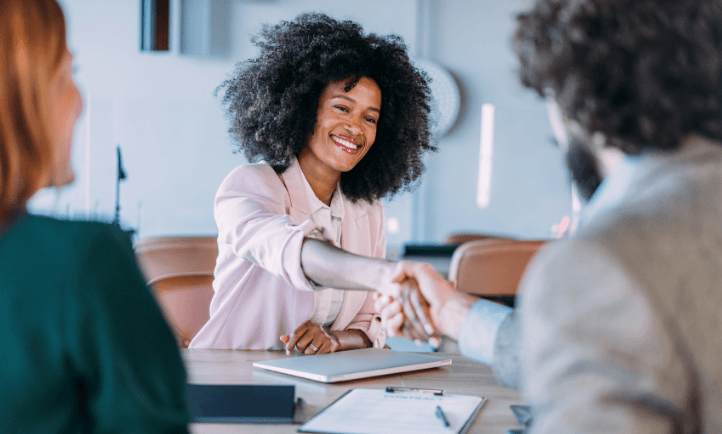 woman in a career pivot interview shaking hands with hiring manager
