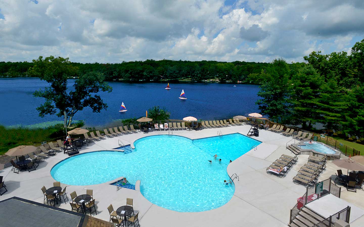 A pool and patio overlooking a lake