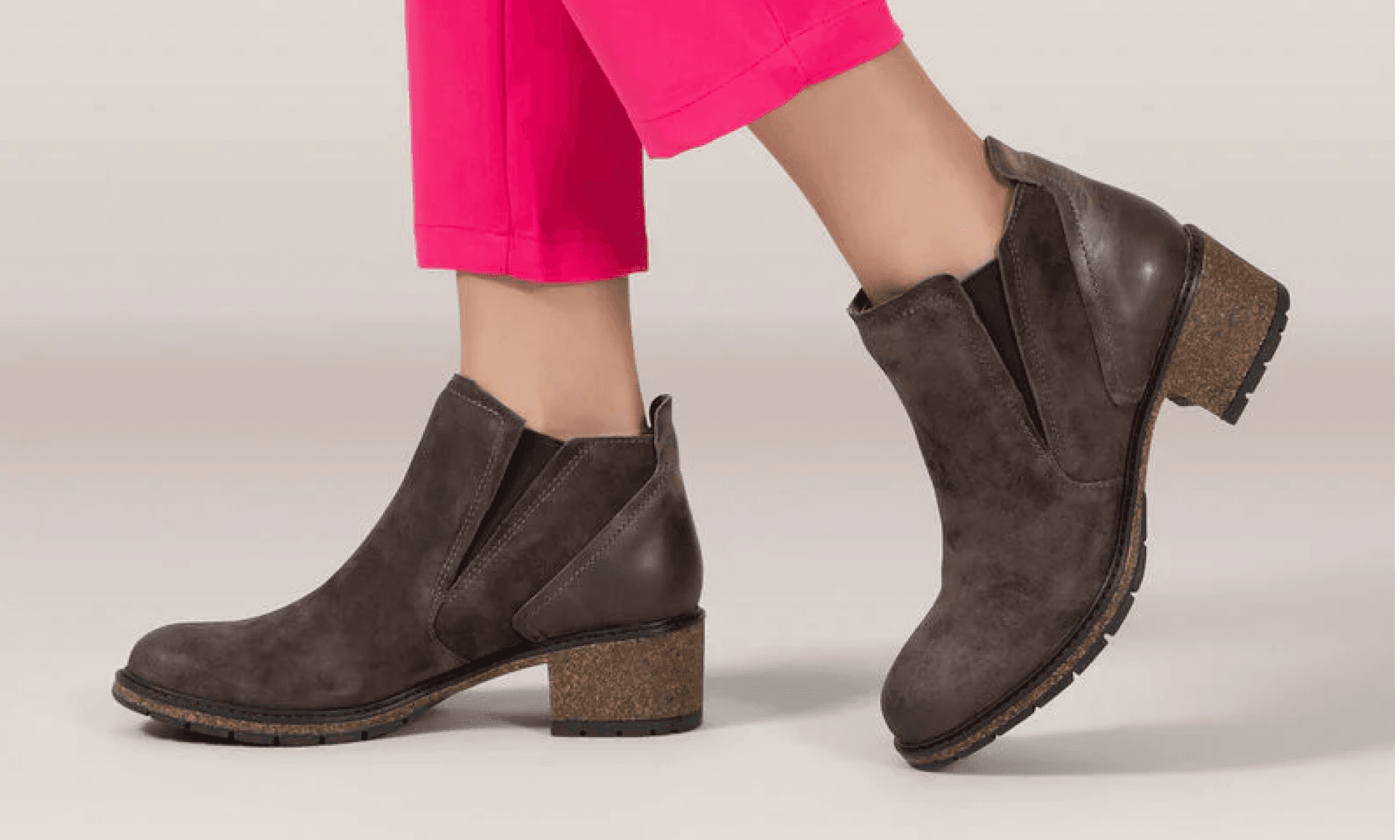 Woman in pink pants wearing brown boots with a cork heel
