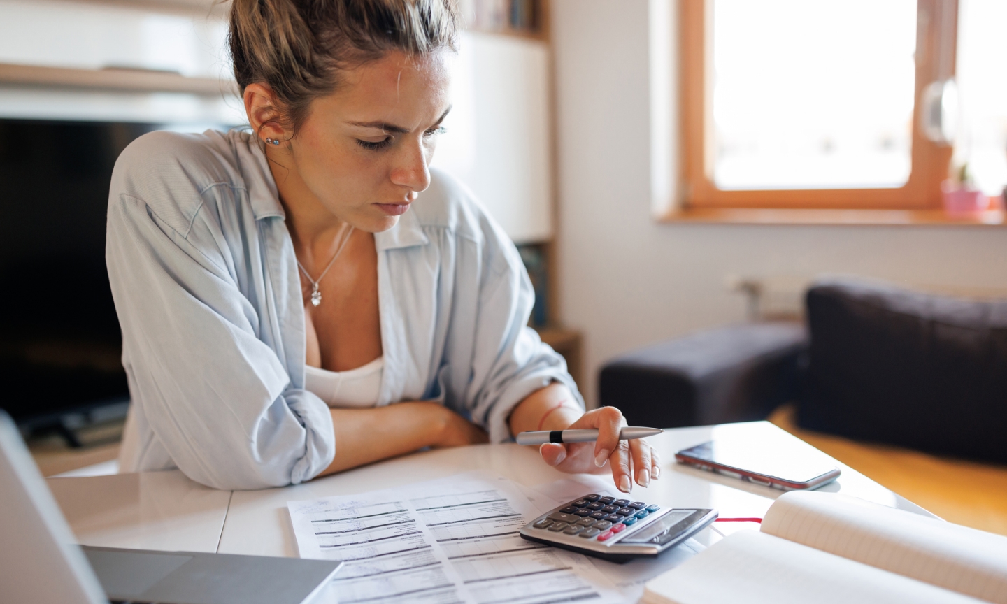 accessibility, woman reviewing paperwork with calculator