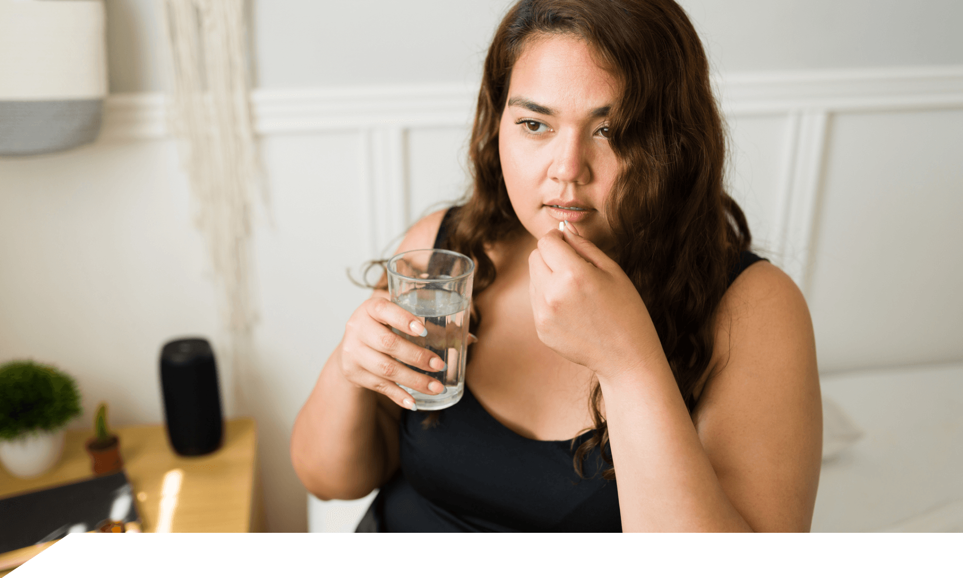 Woman holding pill and glass of water