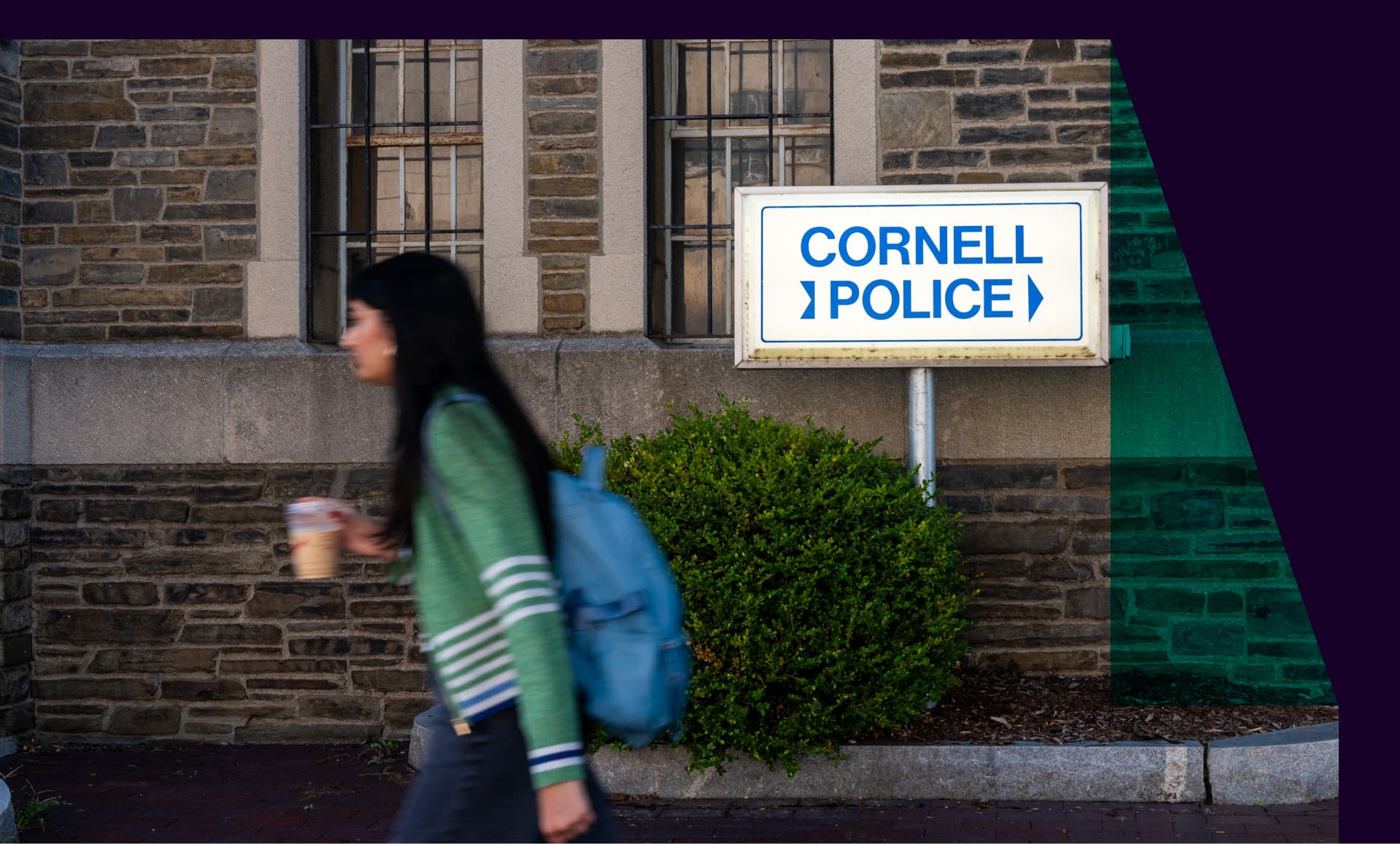 A student walking past a sign that says "Cornell Police"
