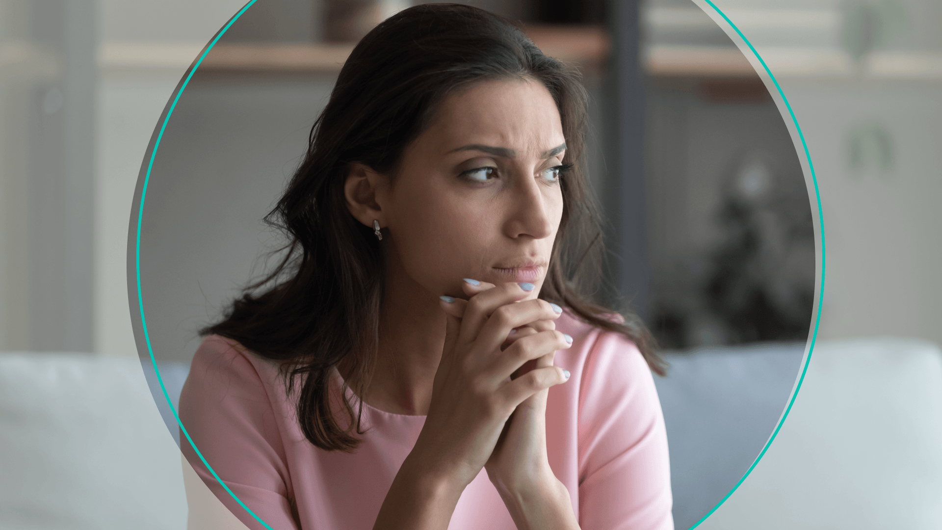 A woman sitting with her chin on her hands, looking stressed