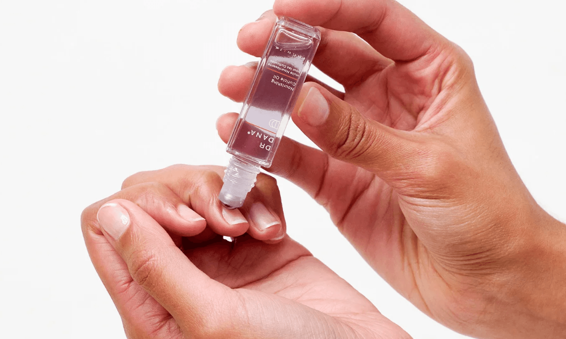 Woman applying cuticle oil to nails