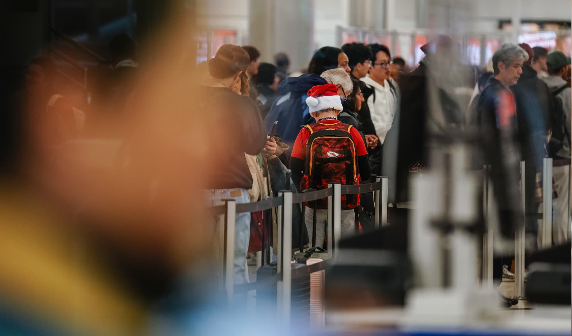 Little boy wearing a Santa hat in line for TSA
