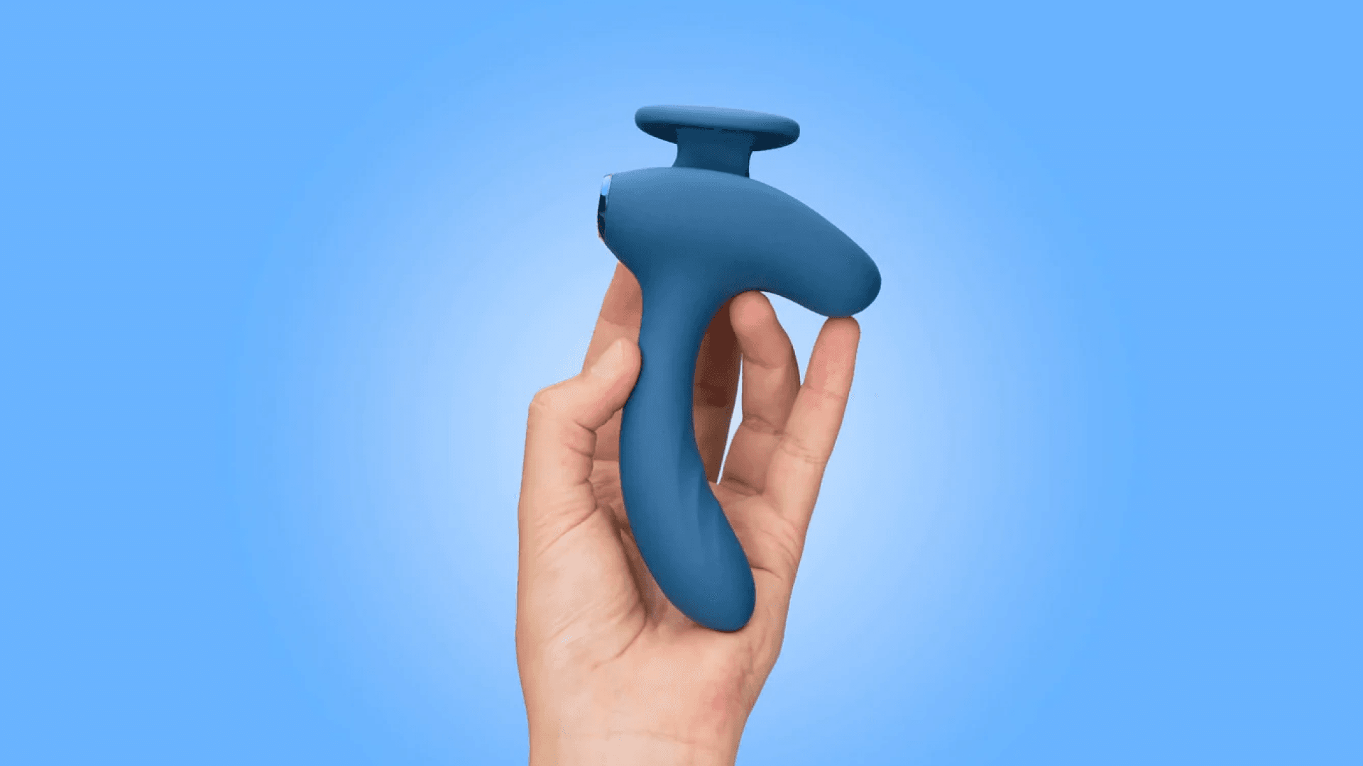 Hand holding blue silicone vibrator with blue background