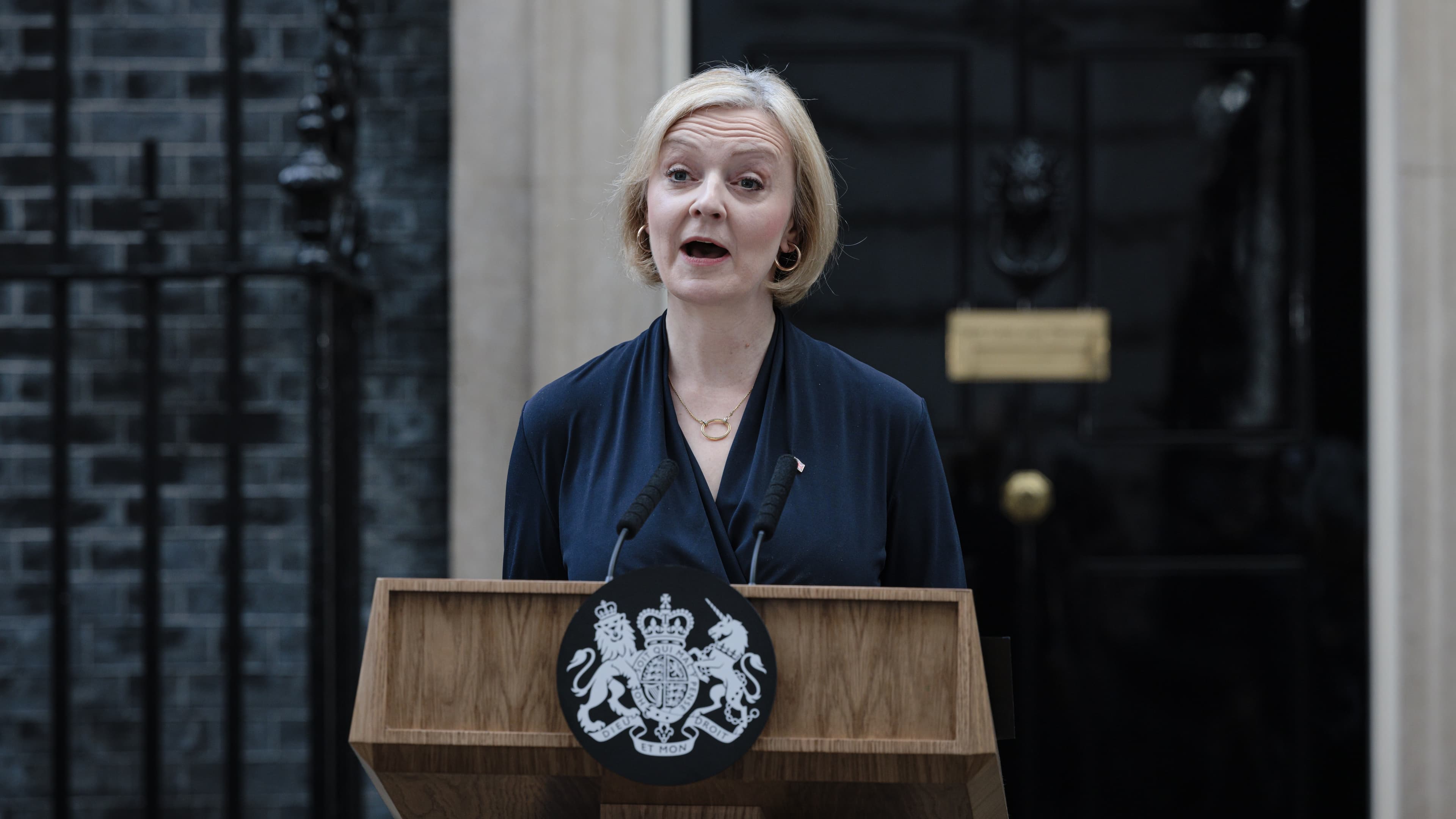 Liz truss, in dark clothing, addressing reporters in front of 10 downing street in London after resigning.