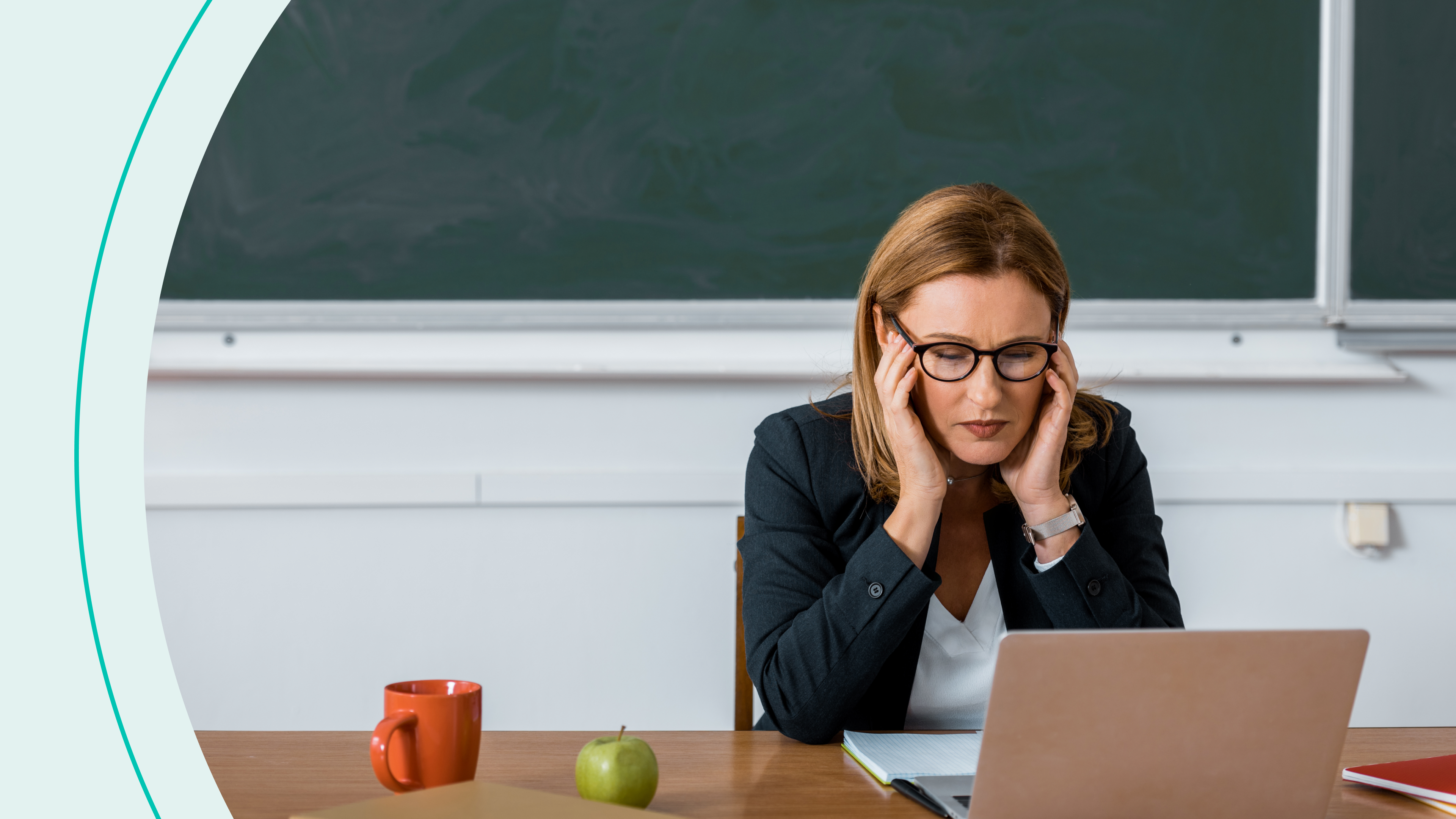 Female teacher sitting at computer desk and having headache in class stock photo